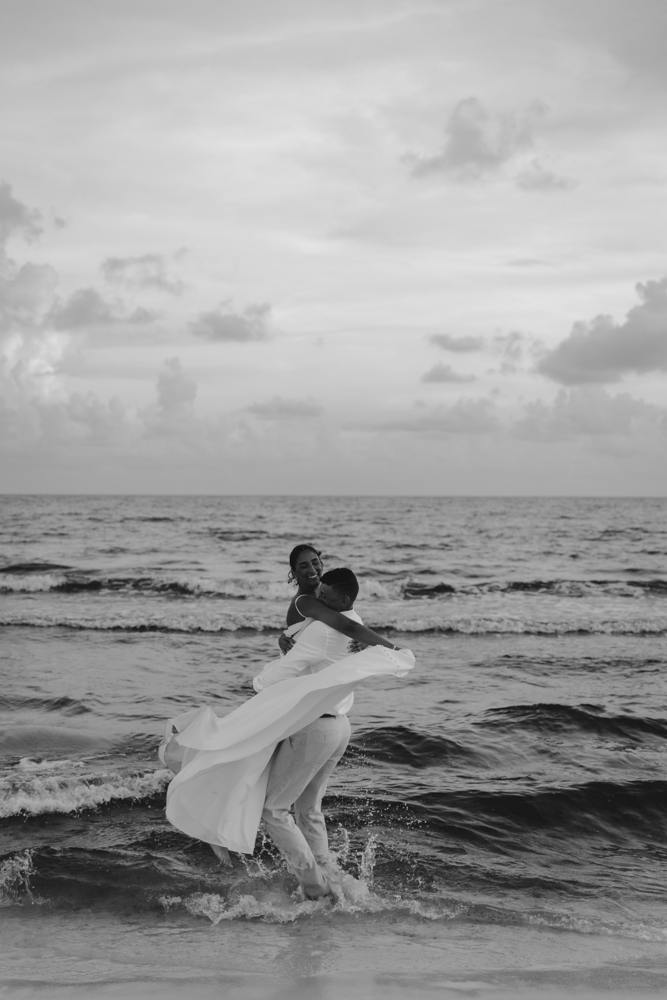A newlywed couple celebrating together at the shoreline